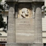 Denkmal Rudolf Virchow auf dem Karlplatz in Berlin-Mitte von Fritz Klimsch, Detailansicht des Sockels mit dem Porträt Virchows