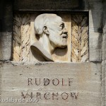 Denkmal Rudolf Virchow auf dem Karlplatz in Berlin-Mitte von Fritz Klimsch, Detailansicht des Sockels mit dem Porträt Virchows