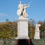 Die aus weißem Marmor aus Carrara angefertigte Skulptur "Athena unterrichtet den Jungen im Waffengebrauch" auf der Schlossbrücke in Berlin-Mitte stammt Hermann Schievelbein aus dem Jahr 1853.