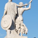 Die aus weißem Marmor aus Carrara angefertigte Skulptur "Athena unterrichtet den Jungen im Waffengebrauch" auf der Schlossbrücke in Berlin-Mitte stammt Hermann Schievelbein aus dem Jahr 1853.