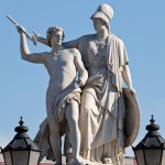 Die aus weißem Marmor aus Carrara angefertigte Skulptur "Athena unterrichtet den Jungen im Waffengebrauch" auf der Schlossbrücke in Berlin-Mitte stammt Hermann Schievelbein aus dem Jahr 1853.