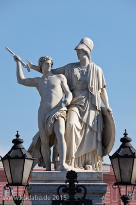 Die aus weißem Marmor aus Carrara angefertigte Skulptur "Athena unterrichtet den Jungen im Waffengebrauch" auf der Schlossbrücke in Berlin-Mitte stammt Hermann Schievelbein aus dem Jahr 1853.