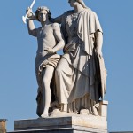 Die aus weißem Marmor aus Carrara angefertigte Skulptur "Athena unterrichtet den Jungen im Waffengebrauch" auf der Schlossbrücke in Berlin-Mitte stammt Hermann Schievelbein aus dem Jahr 1853.