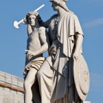 Die aus weißem Marmor aus Carrara angefertigte Skulptur "Athena unterrichtet den Jungen im Waffengebrauch" auf der Schlossbrücke in Berlin-Mitte stammt Hermann Schievelbein aus dem Jahr 1853.