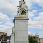 Die aus weißem Marmor aus Carrara angefertigte Skulptur "Athena unterrichtet den Jungen im Waffengebrauch" auf der Schlossbrücke in Berlin-Mitte stammt Hermann Schievelbein aus dem Jahr 1853.