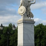 Die aus weißem Marmor aus Carrara angefertigte Skulptur "Athena unterrichtet den Jungen im Waffengebrauch" auf der Schlossbrücke in Berlin-Mitte stammt Hermann Schievelbein aus dem Jahr 1853.