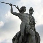 Die aus weißem Marmor aus Carrara angefertigte Skulptur "Athena unterrichtet den Jungen im Waffengebrauch" auf der Schlossbrücke in Berlin-Mitte stammt Hermann Schievelbein aus dem Jahr 1853.