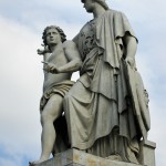 Die aus weißem Marmor aus Carrara angefertigte Skulptur "Athena unterrichtet den Jungen im Waffengebrauch" auf der Schlossbrücke in Berlin-Mitte stammt Hermann Schievelbein aus dem Jahr 1853.